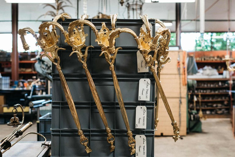 Mehrere goldfarbene Wandleuchten in einem Regal