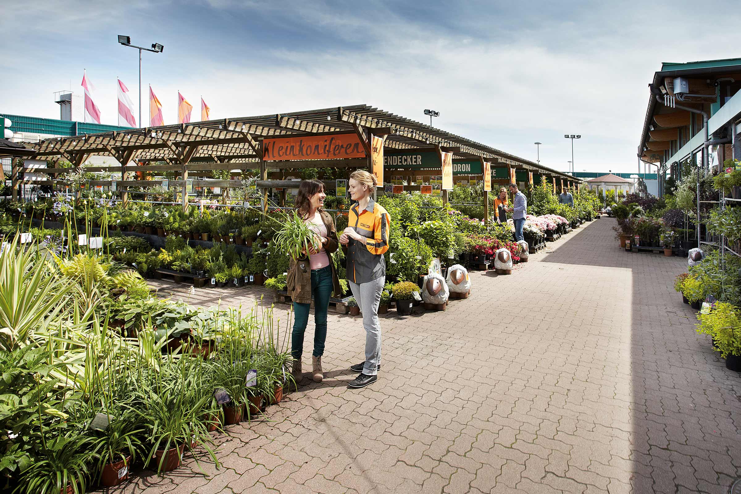 Kunden und Verkäufer im Hornbach Gartencenter, umgeben von Pflanzen
