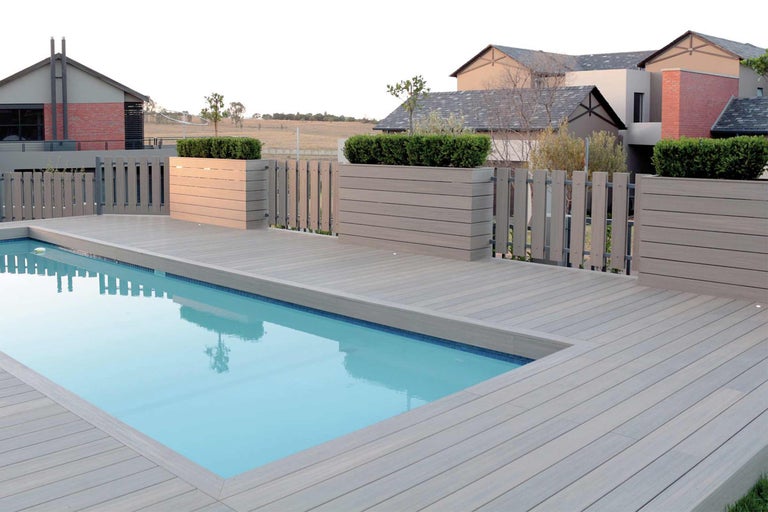 Pool mit Terrasse aus Holz und dekorativen Pflanzenkästen