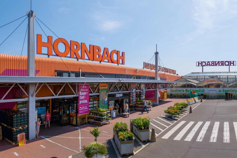 Außenansicht eines Hornbach Bau- und Gartenmarktes mit Eingangsbereich und Parkplatz