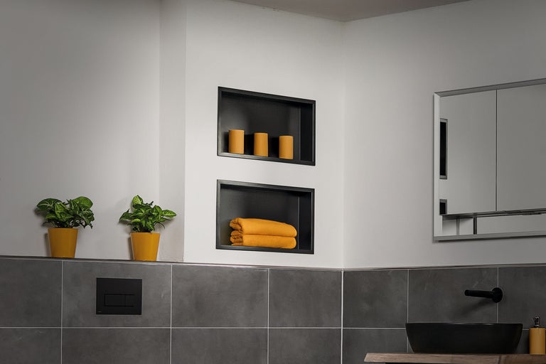 Helles Badezimmer mit Ablagefächern, Handtüchern, Kerzen und Pflanzen