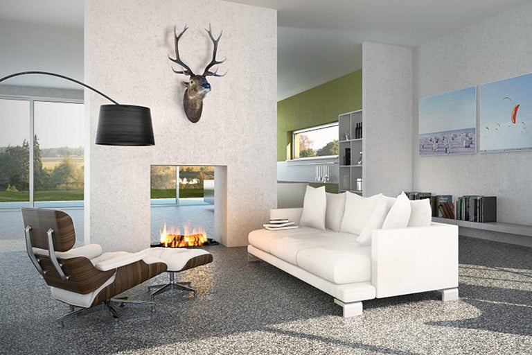 Helles Wohnzimmer mit Kamin, Sofa, Sessel und Geweih an der Wand