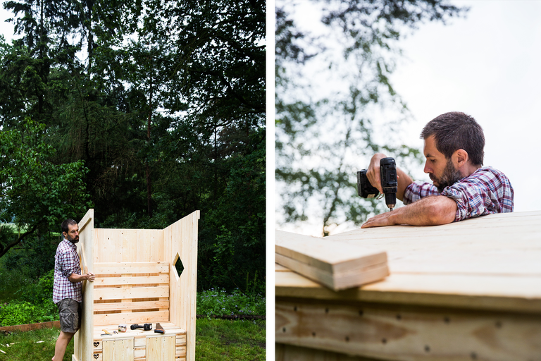 Mann baut ein Holzspielhaus mit Elektrowerkzeugen im Garten.