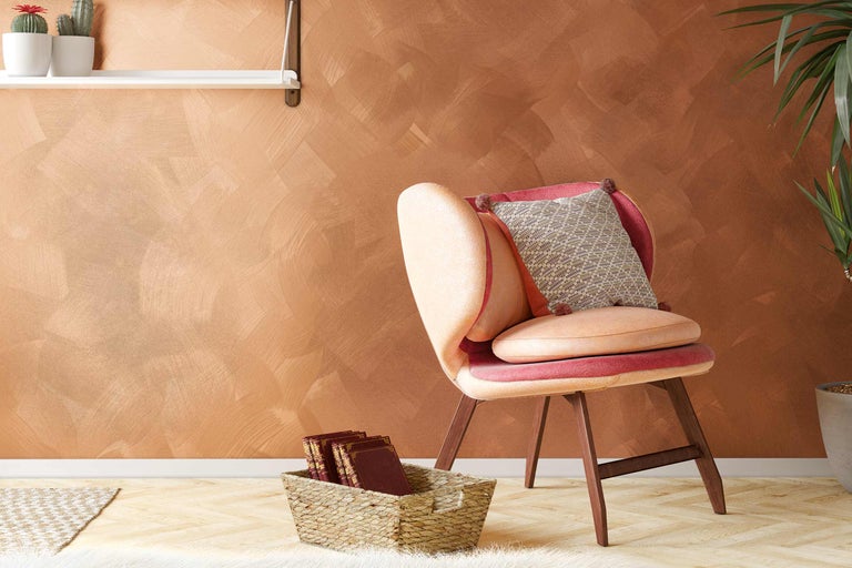 Dekoratives Wohnzimmer mit Sessel, Kissen, Regalen und Pflanze