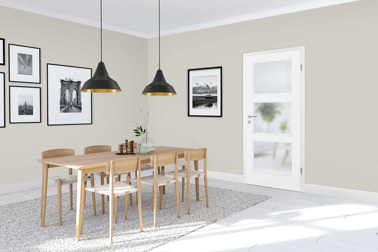 Heller Essbereich mit Holztisch, Stühlen und weißer Innentür mit Glaseinsätzen.