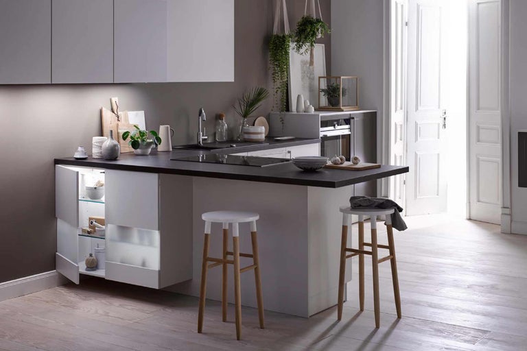 Helle Küche mit Kücheninsel, Barhockern und offener Tür