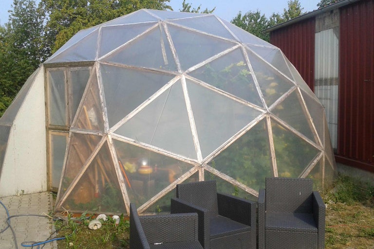 Geodätisches Kuppelgewächshaus mit Gartenmöbeln