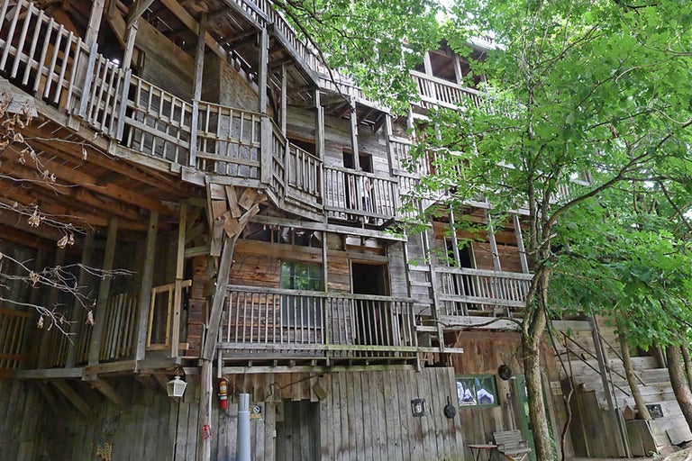 Mehrgeschossiges Baumhaus aus Holz mit mehreren Balkonen und Treppen.