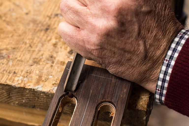 Handwerker bearbeitet Holz mit einem Stecheisen.