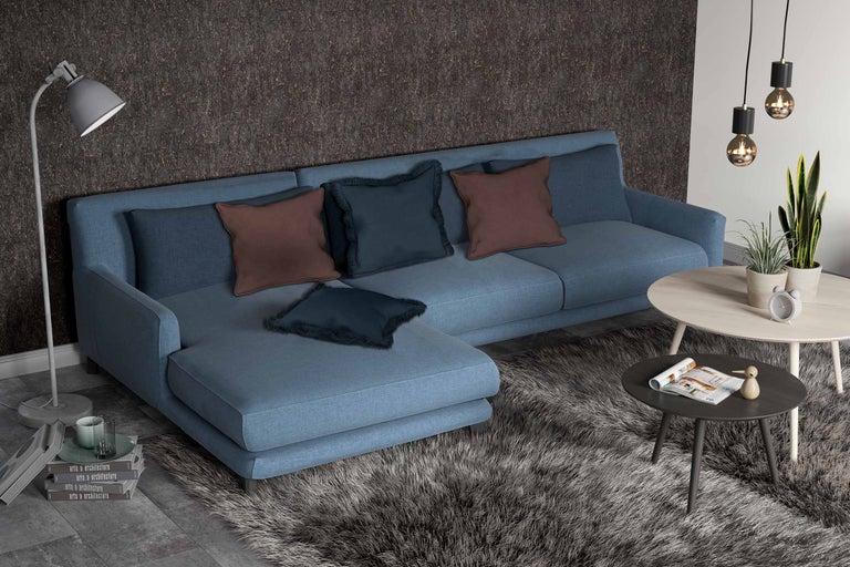 Wohnzimmer mit Ecksofa, Kissen, Teppich und Beistelltischen.