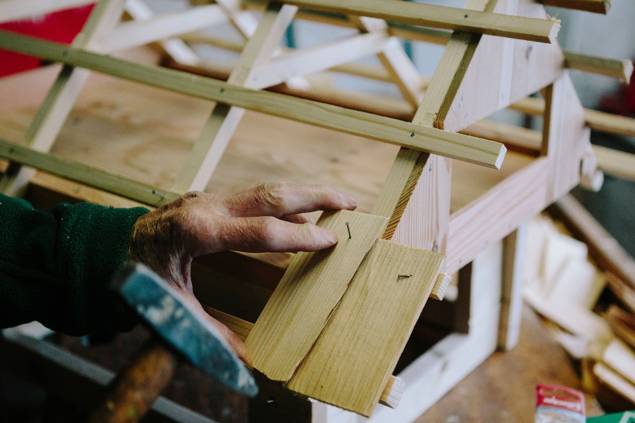 Handwerker nagelt Holzkonstruktion zusammen.