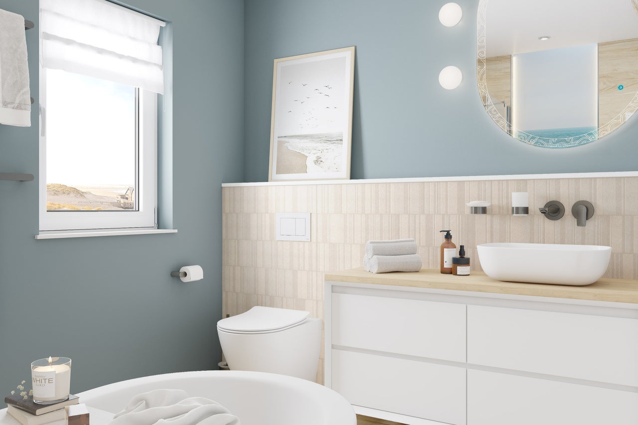 Helles Badezimmer mit Badewanne, Toilette, Waschtisch mit Spiegel und Fenster