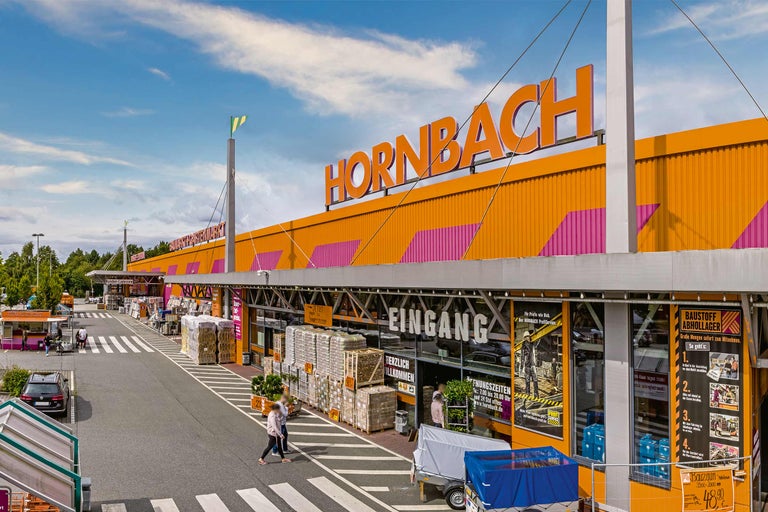 Außenansicht eines Hornbach Baumarktes mit Eingangsbereich und Kundenparkplatz