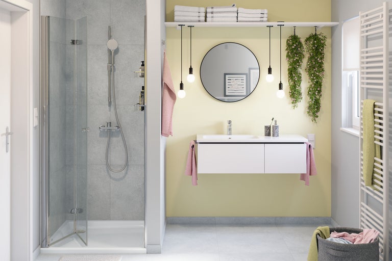 Badezimmer mit Dusche, Waschtisch, Spiegel und Handtuchwärmer