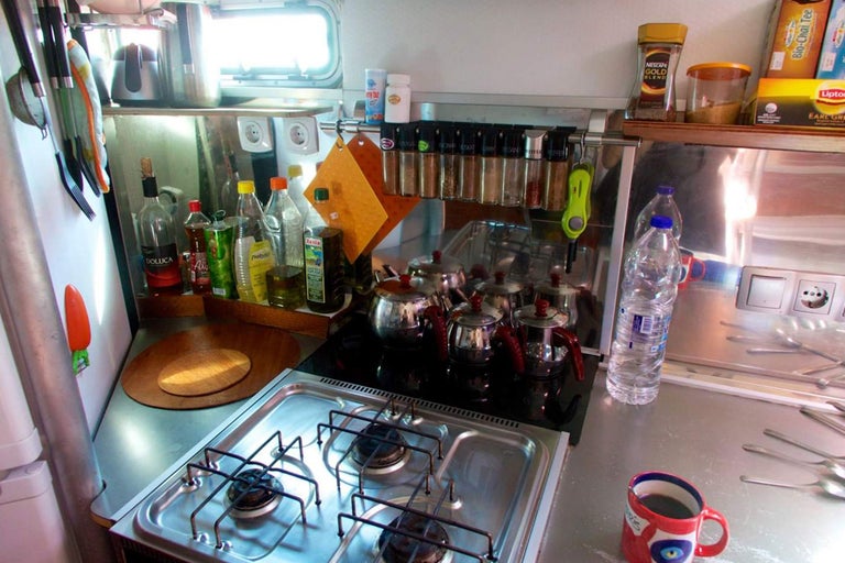 Küchenszene mit Kochfeld, Spülbecken und verschiedenen Küchenutensilien