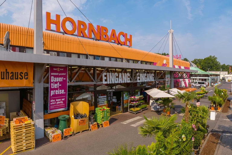 Außenansicht eines Hornbach Baumarktes mit Eingangsbereich und Gartenausstellung.