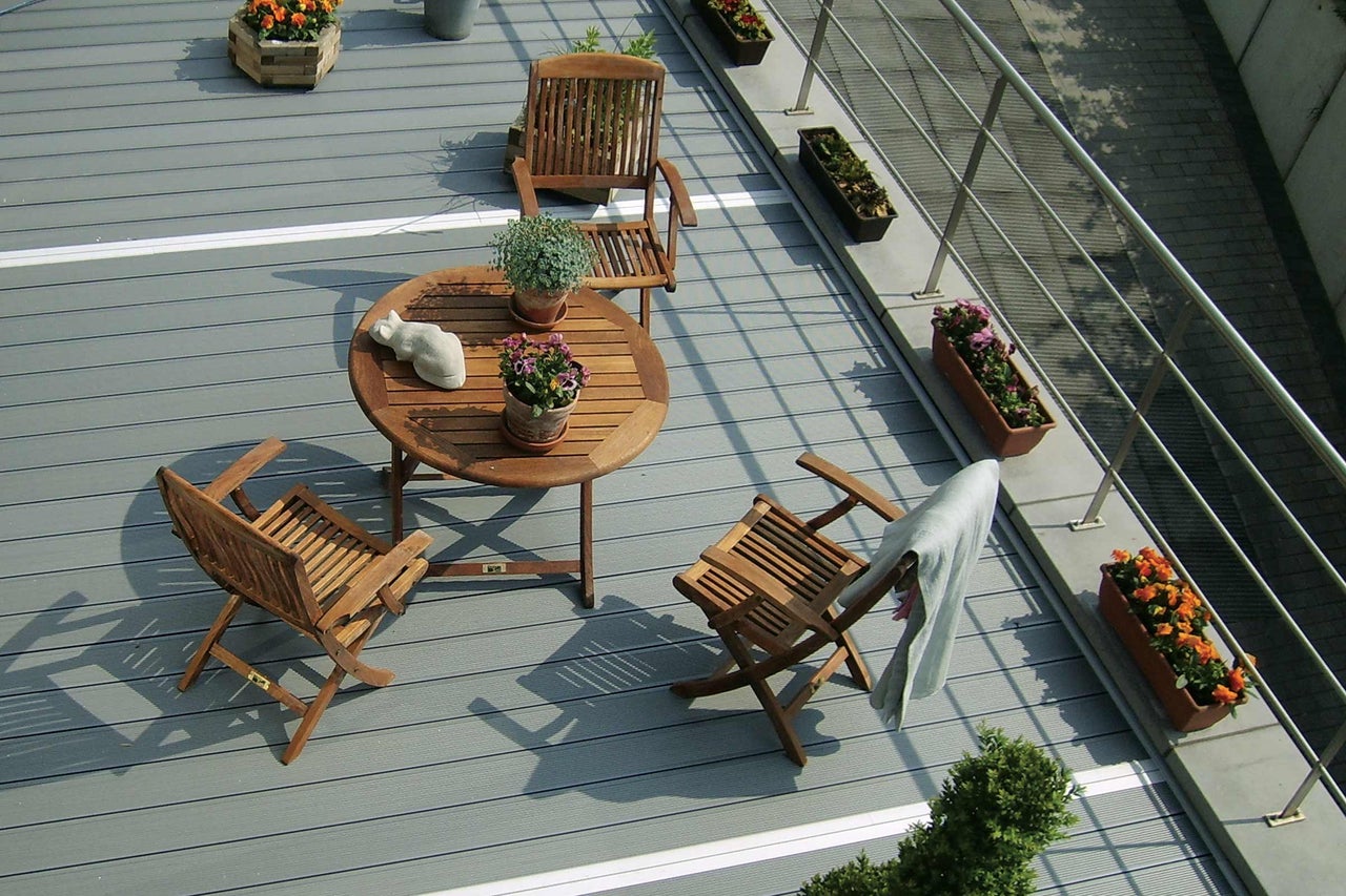 Terrasse mit Holzboden, Holztisch und Holzstühlen