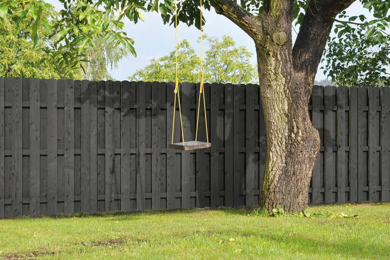 Szene mit einem Holzzaun und einer an einem Baum befestigten Schaukel