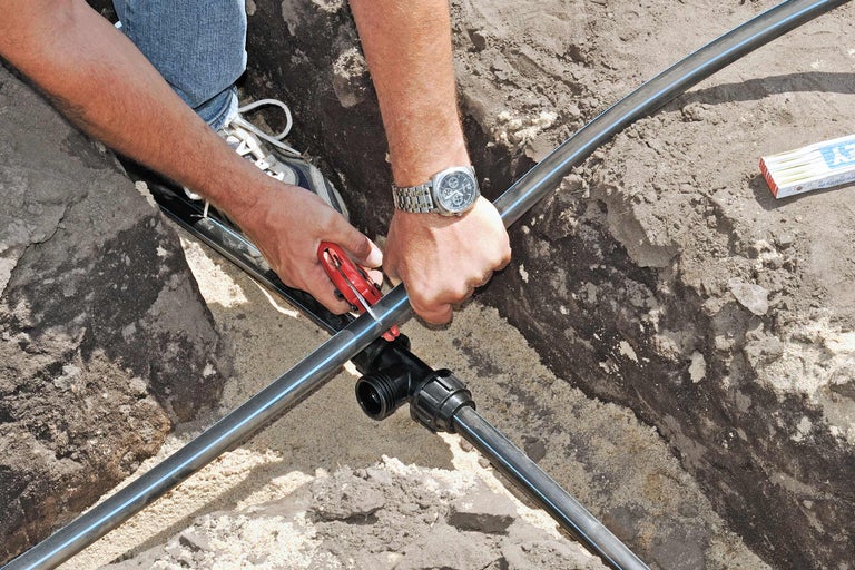 Installation einer Bewässerungsleitung mit einem T-Stück und Rohrschneider