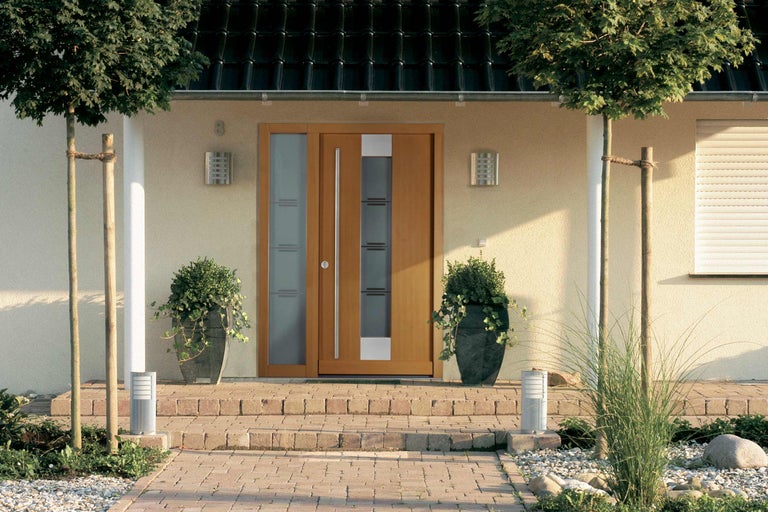 Eingangsbereich eines Hauses mit Haustür und Pflanzenkübeln