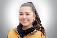 Porträt einer lächelnden Frau in Arbeitskleidung