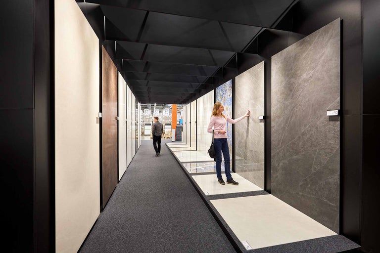 Ausstellung von Bodenfliesen im Hornbach Markt mit Kunden, die verschiedene Designs und Materialien betrachten