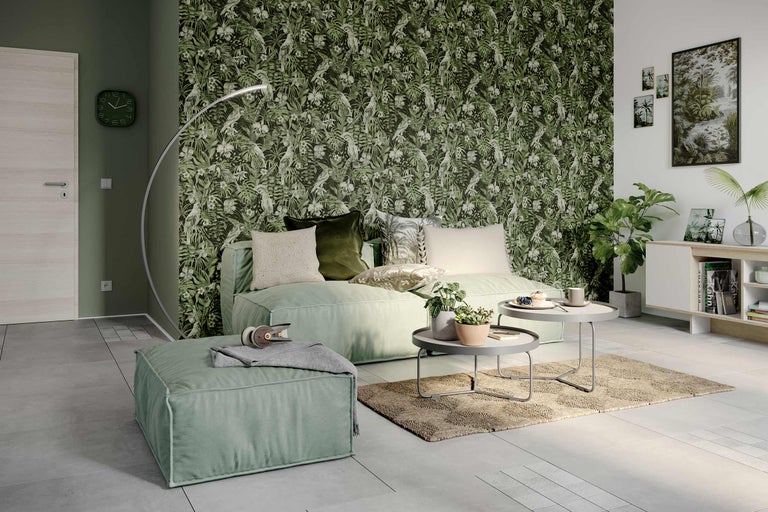 Wohnzimmer mit grüner Dschungeltapete, Sofa, Pouf, Teppich und Beistelltischen