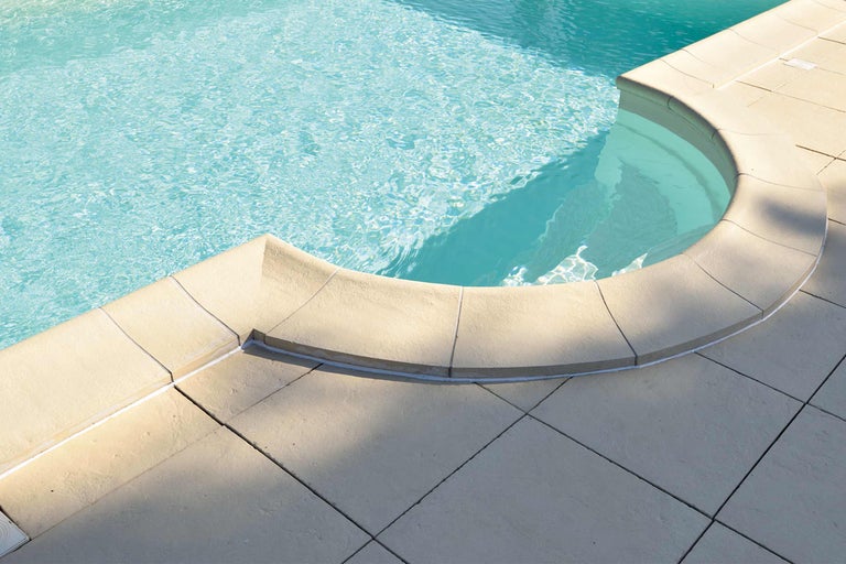 Detailansicht eines Pools mit Beckenrandsteinen und Fliesen
