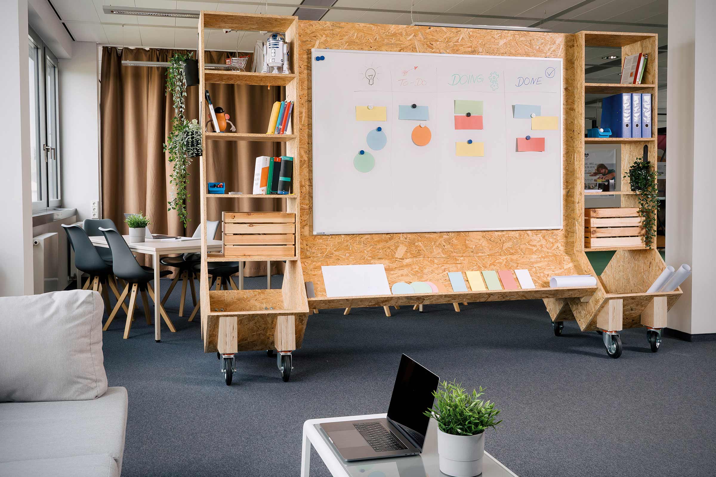 Büro mit mobilem Raumteiler, Whiteboard und Regalen aus Holz