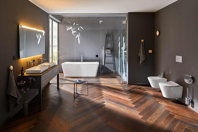 Badezimmer mit Badewanne, Dusche, Waschtisch, Toilette und Bidet in dunkler Farbgebung