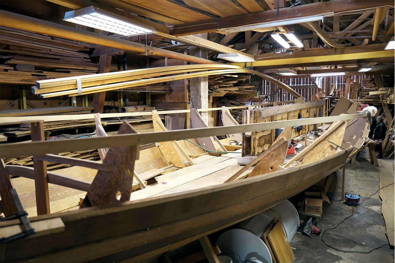 Werkstatt mit unfertigem Holzboot im Bau