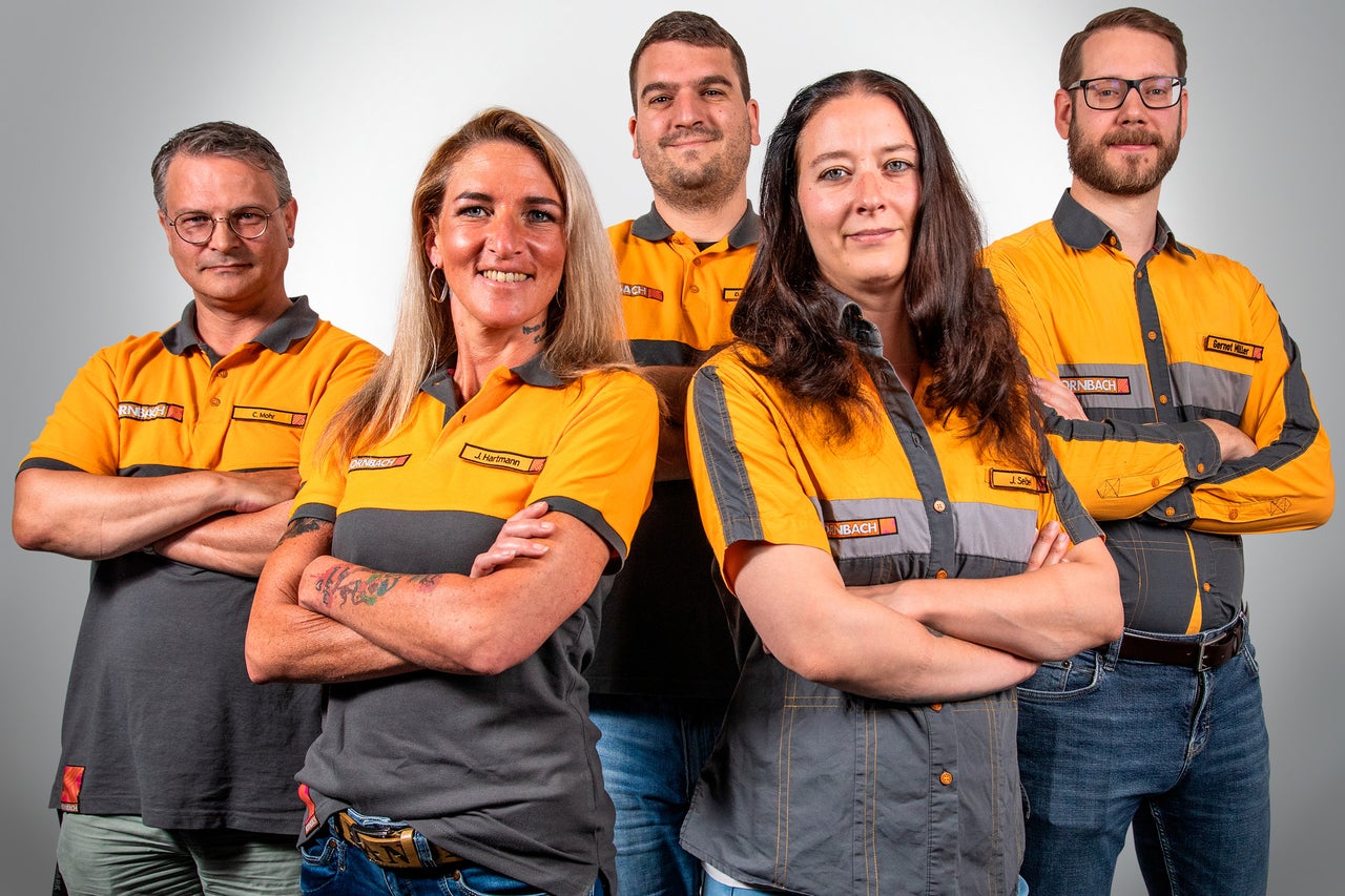 Eine Gruppe von Hornbach Mitarbeitern in Arbeitskleidung posiert für ein Foto.