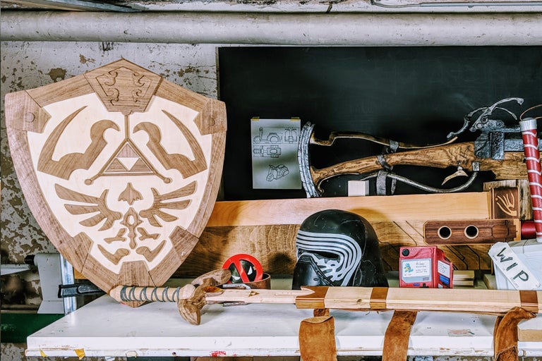 Werkstattszene mit handgefertigtem Holzschild, Helm, Spielzeugpistole und Werkstattzubehör