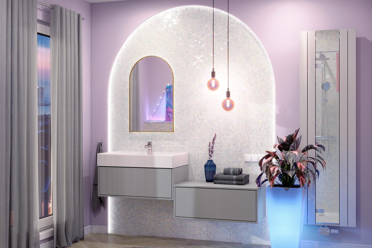 Modernes Badezimmer mit grauem Waschtischunterschrank, weißem Waschbecken, Rundbogenspiegel und beleuchteter Mosaikwand.