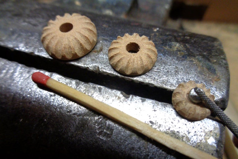 Drei hölzerne Schmuckperlen mit Loch und Streichholz