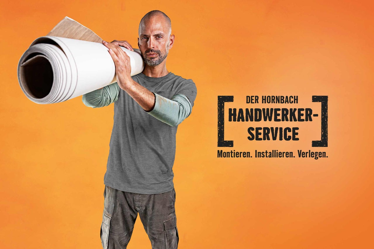 Ein Mann trägt eine Rolle Bodenbelag auf der Schulter, im Hintergrund das Hornbach Handwerker-Service Logo.