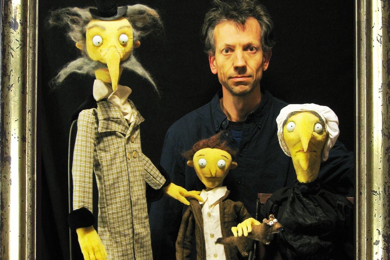 Mann mit Puppen in einem goldenen Rahmen