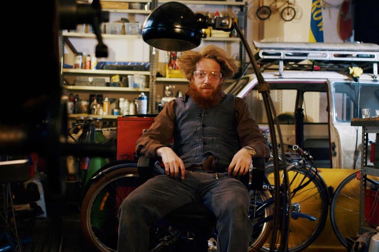 Werkstattszene mit einer sitzenden Person, Fahrrädern und Regalen