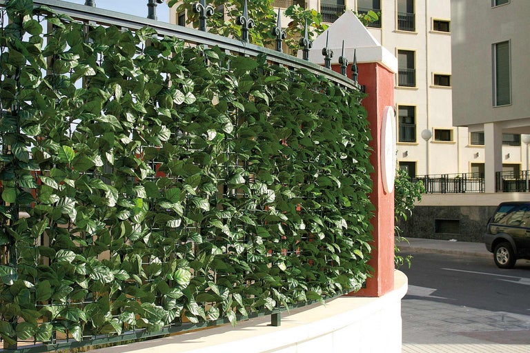 Zaun mit künstlichen Efeublättern als Sichtschutz