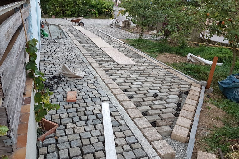 Verlegung von Pflastersteinen im Außenbereich mit Pflastersteinen und Steinplatten