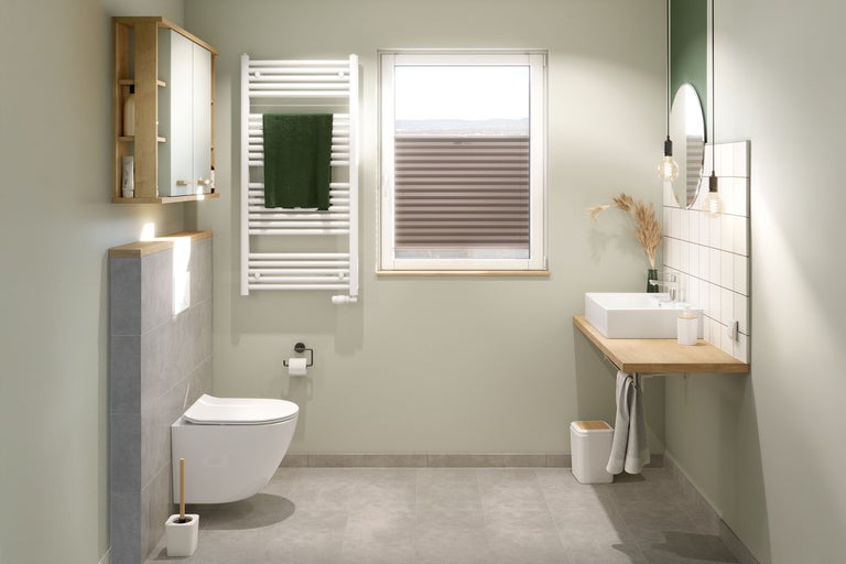 Helles Badezimmer mit Toilette, Waschbecken, Spiegel und Heizkörper