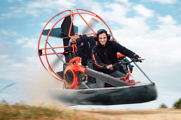 Mann fährt mit einem Luftkissenboot, ausgestattet mit einem Laubbläser