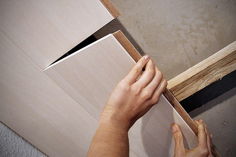 Person befestigt Paneele an der Decke