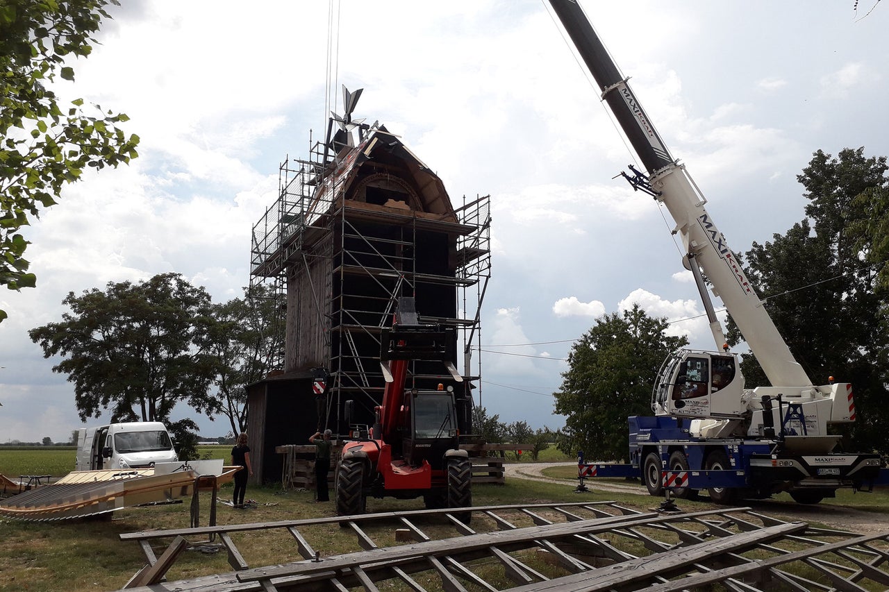 Restaurierung einer alten Windmühle mit Kran und Gerüst