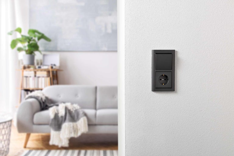 Schalter und Steckdose in einem modern eingerichteten Wohnzimmer.