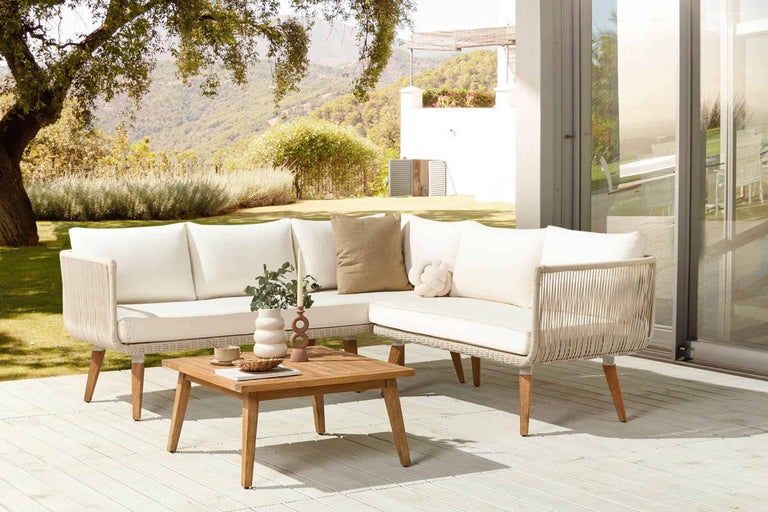 Gartensitzgruppe mit Sofa, Sessel und Holztisch auf einer Terrasse