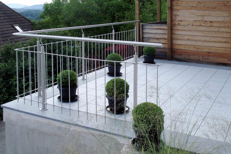 Balkon mit Edelstahlgeländer, Fliesenboden und Topfpflanzen