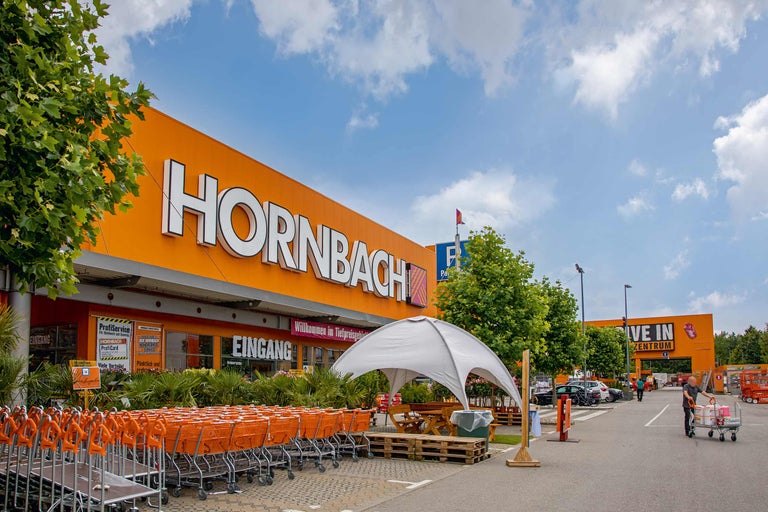 Außenansicht eines Hornbach Baumarktes mit Einkaufswagen und Parkplatz