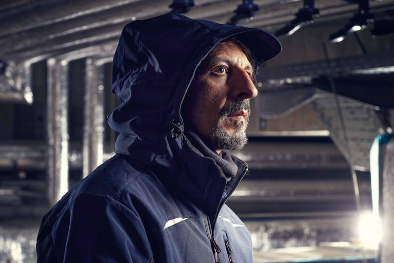 Mann mit Kapuze trägt Arbeitsjacke