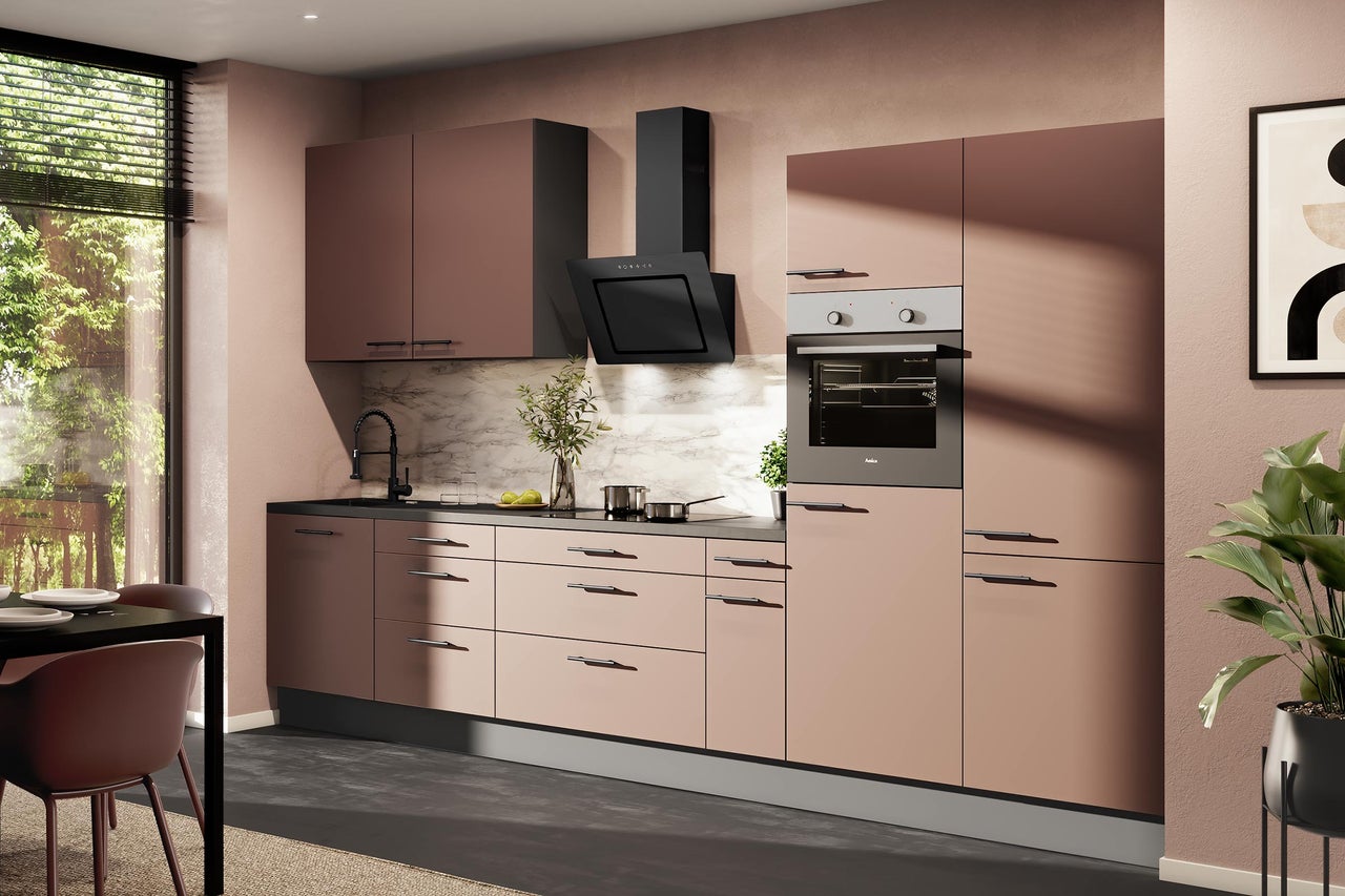 Moderne Einbauküche in Altrosa mit schwarzen Griffen, Elektrogeräten, Dunstabzugshaube, Backofen und Marmor-Rückwand.